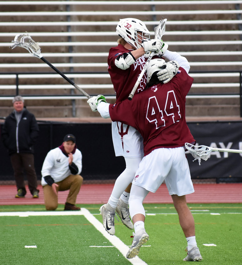 Golden juniors Garrett Landmark (44) and Kevin Mulligan celebrate a first-quarter goal Monday, May 20, at All-City Stadium during the Class 4A boys lacrosse state championship game against Cheyenne Mountain.